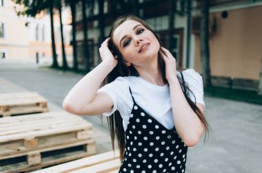 Uzun siyah sarafan güzel bir kız sokakta yürür. 