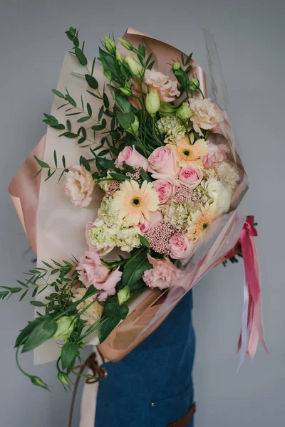 Очень красивая женщина-флорист с красивым цветным цветком — стоковое фото