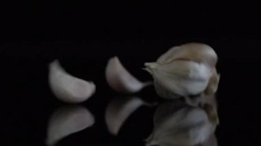 Sarımsak ağır çekim siyah arka plan üzerine düşmek. Pişirme kavramı ve tarımsal ürün.