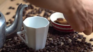 Bir fincan kahve yapmak. Adamın elleri kahve tozu scooping ve bir cam koymak ve çaydanlık sıcak suyu cam içine akıt.