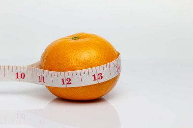 Closeup mandalina etrafında bant ölçme ile sarılmıştı. Sevgi ve sağlık veya diyet kavramı.
