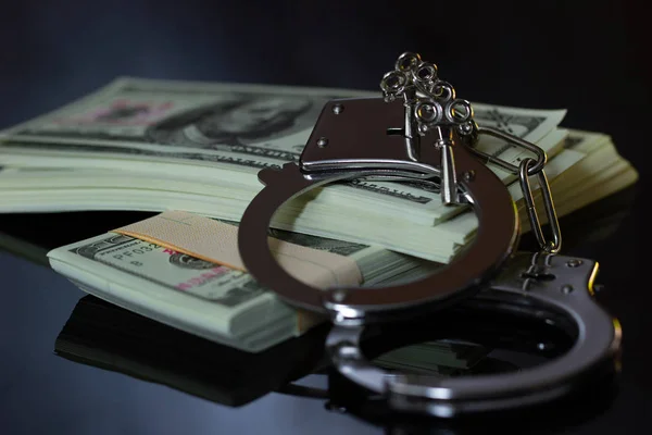 Kelepçe ve para karanlıkta. İş dolandırıcılık ve yolsuzluk kavramı.