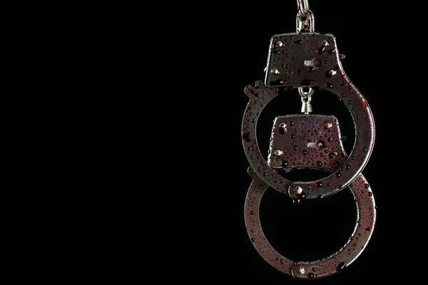 Handcuffs were hung and droplets of fake blood in darkness backg — Stock Photo, Image