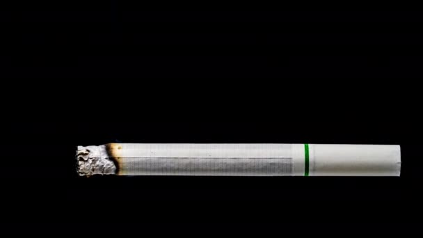 時間経過クローズアップ白いタバコは 黒い背景に燃えています タバコの概念は ゆっくりとあなたの人生を燃やすか 反タバコを吸うのをやめるためのキャンペーンを行います — ストック動画