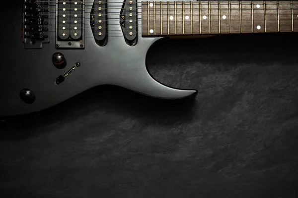 Black electric guitar on black cement floor. — Stock Photo, Image