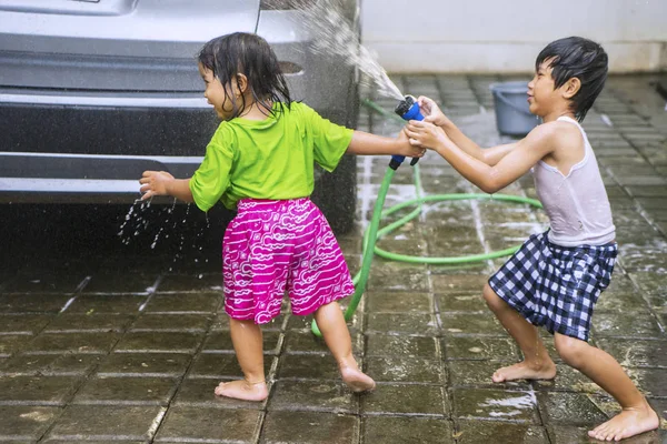 可爱的小孩子在玩水溅和在家洗车时看起来很开心 — 图库照片