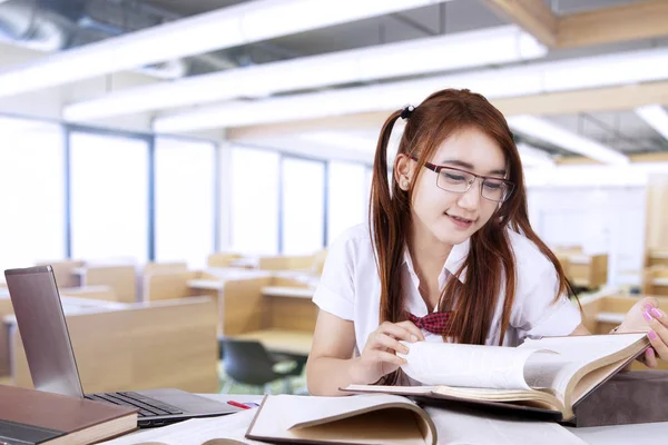 学校に戻るのコンセプトです 教室でメガネをかけて 本を読んでいる間かなり十代の留学 — ストック写真