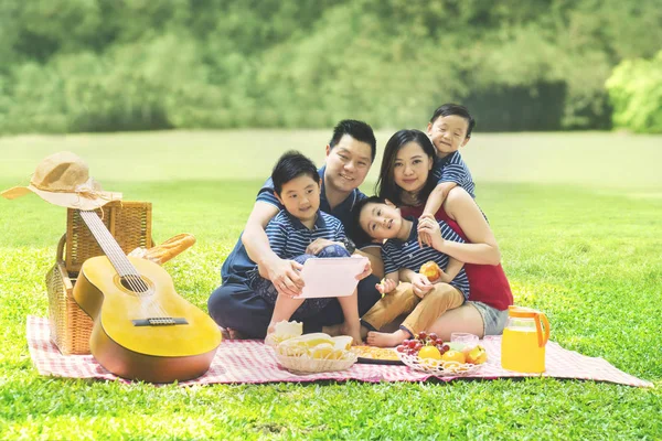 Imagem Família Chinesa Usando Tablet Digital Enquanto Faz Piquenique Parque — Fotografia de Stock