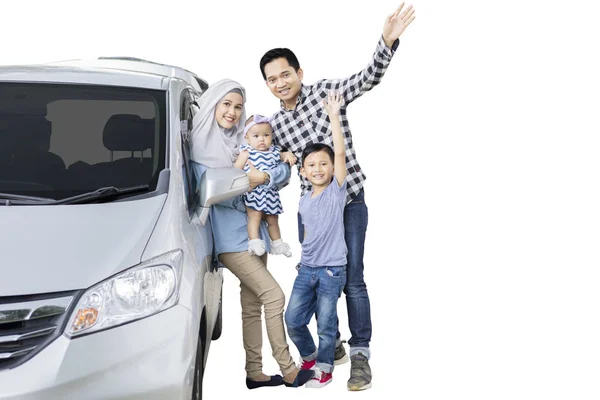 白い背景に分離カメラで手を振りながら自分の車に近いイスラム教徒家族立っての画像 — ストック写真