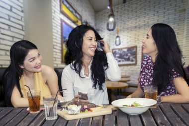 Kafede sohbet ederken birlikte öğle yemeği üç mutlu Bayan resmi