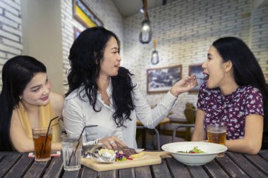 Görüntü genç kadının arkadaşı öğle birlikte kafede tadını çıkarırken bir biftek tatmaya besleme