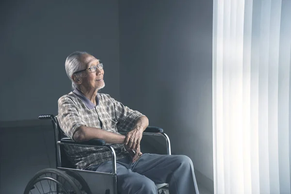 Starszy Mężczyzna Wygląda Szczęśliwy Siedząc Wózku Marzeń Przez Okno Strzał — Zdjęcie stockowe
