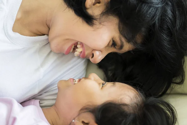 Bild Lycklig Liten Flicka Leker Med Hennes Mamma Liggande Soffan — Stockfoto