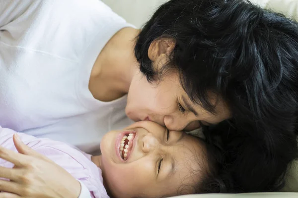 Close Little Girl Being Kissed Her Mother While Lying Couch — Stock Photo, Image