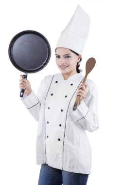 Beyaz arka plan üzerinde izole Studio, spatula ve tava dururken tutan kadın şef portresi