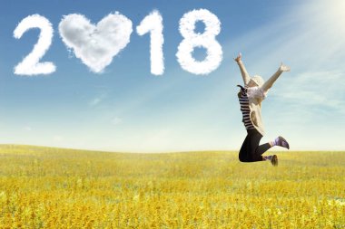 Genç kadının özgürlük alanı üzerinde atlama. Yeni yıl 2018 kavramı.