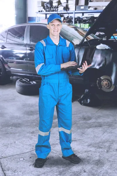 美国男性机械师在站在车间时使用膝上型计算机的完整长度 — 图库照片