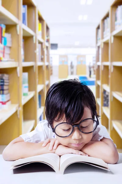 Foto Van Schattige Schoolmeisje Lezen Een Leerboek Zittend Bibliotheek — Stockfoto