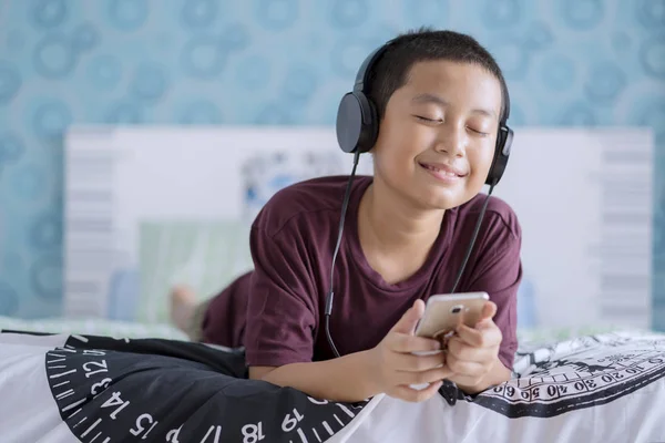 Imagen Niño Adorable Disfrutando Música Usando Teléfono Inteligente Mientras Está —  Fotos de Stock