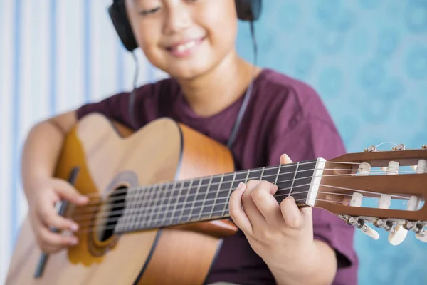 Vértes Kisfiú Játszik Akusztikus Gitár Fejhallgató Viselése Lövés Otthon — Stock Fotó