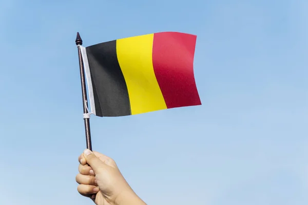 Zbliżenie Małych Rączek Dziecka Macha Flagę Belgii Błękitne Niebo Tła — Zdjęcie stockowe