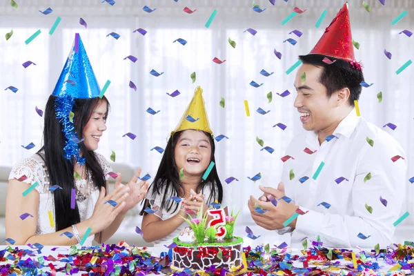 自宅で座っている間彼女の両親と一緒に誕生日パーティーを祝う小さな女の子の肖像画 — ストック写真