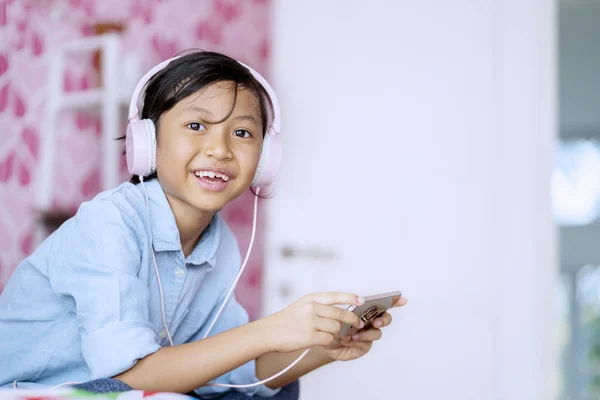 Imagen Una Niña Feliz Disfrutando Música Usando Teléfono Inteligente Mientras —  Fotos de Stock