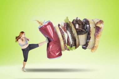 Sağlıksız yiyecek ve içecek yeşil ekran arka planı ile tekme ise spor giyim giymiş obez kadın görüntüsünü