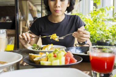 Genç kadın lüks restoranda otururken biftek yemek için çatal ve bıçak kullanarak closeup