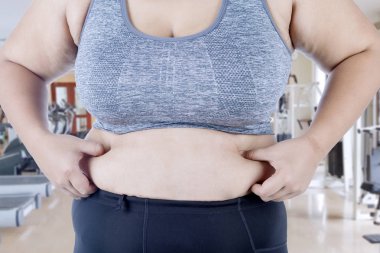 Onun karın yağ spor merkezinde dururken pinching bilinmeyen bir kadın elinde