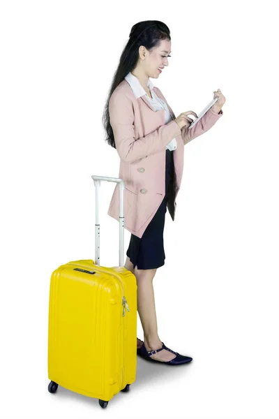 全长的美丽的女商人使用数字平板 而站在与行李 在白色背景下隔离 — 图库照片