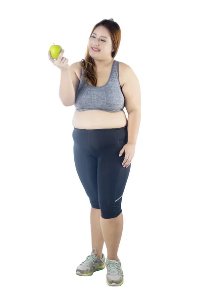 新鮮なリンゴ 白い背景で隔離を押しながらスポーツウェアを着て美しい太った女性の完全な長さ — ストック写真
