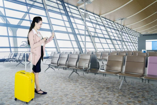 空港のラウンジで 荷物を持って立っている間デジタル タブレットを使用して若い実業家の画像 — ストック写真