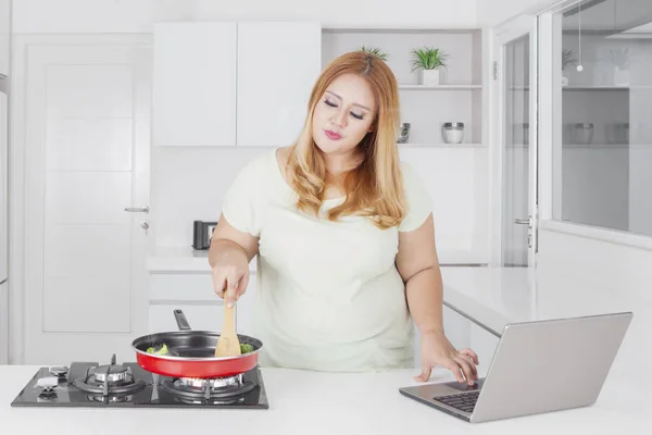 Bild Kaukasiska Överviktig Kvinna Med Laptop Och Matlagning Grönsaker Köket — Stockfoto