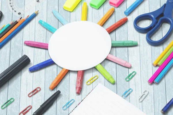 Closeup of an empty round paper with colored stationery on the table