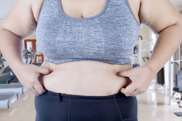 Onun karın yağ spor merkezinde dururken pinching bilinmeyen bir kadın elinde