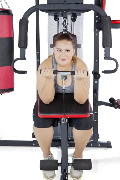 배경에 감량을 운동을 체육관 기계를 뚱뚱한 여자의 초상화 — 스톡 사진
