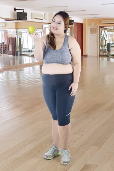 Obez Kadın Tam Uzunlukta Bir Yeşil Elma Tutarak Fitness Merkezinde — Stok fotoğraf