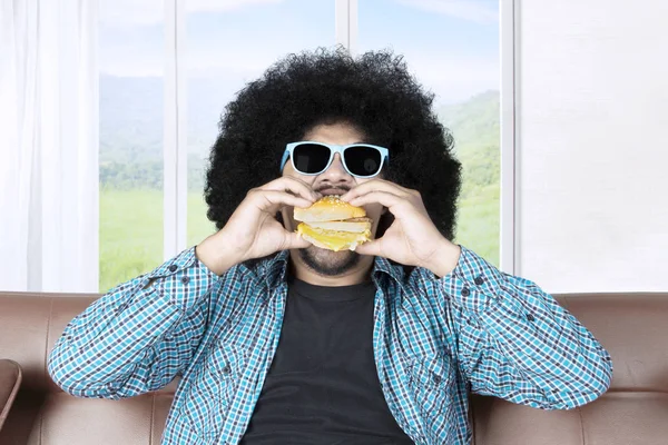 Afro Mladý Muž Kudrnatými Vlasy Nosit Sluneční Brýle Těší Cheeseburger — Stock fotografie