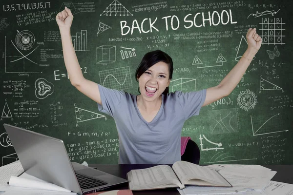 Kolej Öğrenci sınıfta okuyan ve kara tahta üzerinde karalamalar ile oturan eller yükselterek resmini