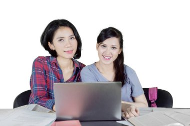 İzole üzerinde beyaz arka plan birlikte, eğitim sırasında kameraya gülümseyen iki kadın üniversite öğrencileri