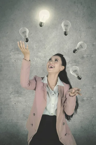 Picture Beautiful Female Entrepreneur Looks Happy While Juggling Light Bulbs — Stock Photo, Image