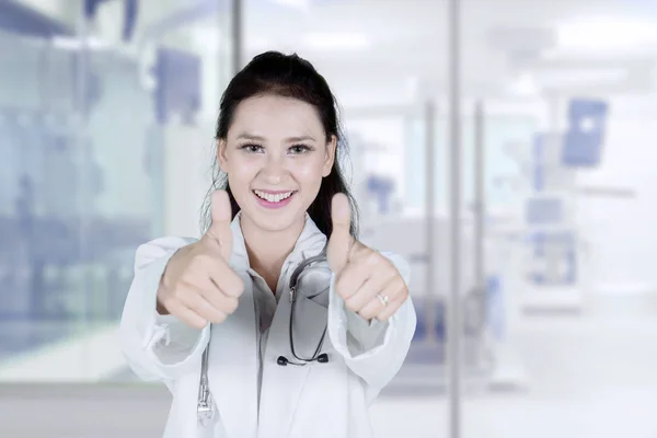 病院に立ちながらカメラに親指を現れる美しい女性医師のクローズ アップ — ストック写真