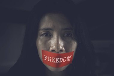 Görüntü saldırıya kızın ağzına bir bürokrasi özgürlük kelime/EC ile üzgün görünüyor. Karanlıkta ateş Oda