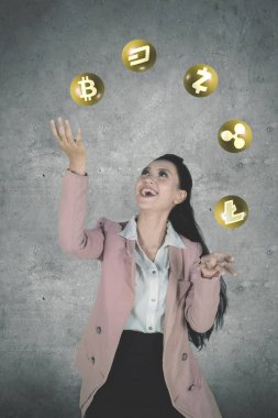 Genç işkadını Cryptocurrency sembolleri duran mutlu ifade ile hokkabazlık portresi