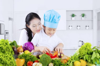 Sevimli küçük boy kesme Sebze Doğrama tahtası evde mutfakta annesiyle