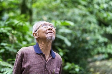 Süre onun tatil zevk ve parkta duran yaşlı bir adam closeup mutlu görünüyor