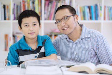 Resmi taşımak çocuk öğrenci okul öğretmeni kütüphanede ile yaparken kameraya seyir