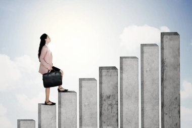 Çok kadın girişimci bir bavul büyüme mali grafik üzerinde yürürken elinde portresi