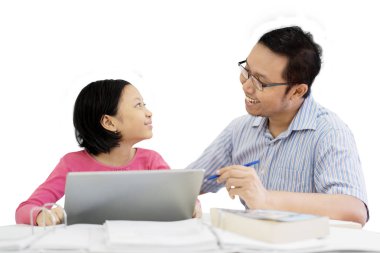 Görüntü bir genç baba kızını beyaz arka plan üzerinde izole stüdyoda otururken bir dizüstü bilgisayar kullanmak kılavuzları